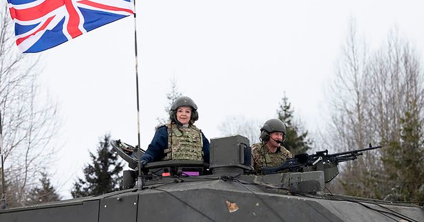 Liz Tuss wearing military uniform and sitting in a tank
